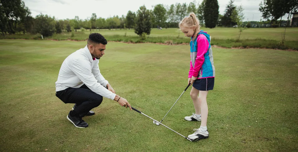 A golf trainer teaching a closed stance