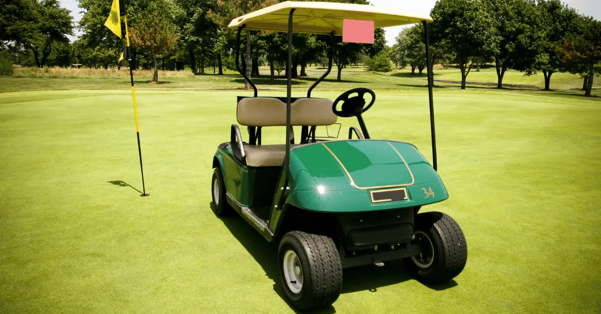 A green golf cart parked on a golf course